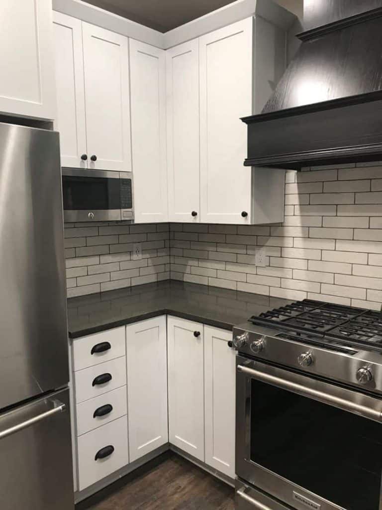 Since the decorative hood was a must… we tucked a space-saver microwave on the right-hand side of the refrigerator panel. The corner base units now consisted of drawer space and a lazy susan for easy access.