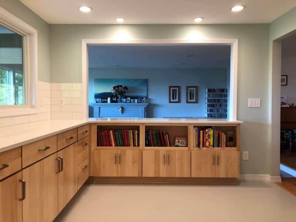 Same view from the range... One request for the remodel was to have a good spot for cookbooks. The shelving units at the end the kitchen are shallow enough to keep the walkway open, and deep enough for all those recipes.