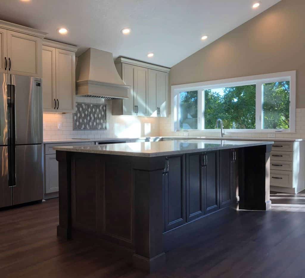 With a large center island and an abundance of countertop space, there is plenty of room for the whole family to interact while meals are being prepared. By installing a nine-foot long window above the sink, we have created a space that connects the inner and outer beauty of this property.