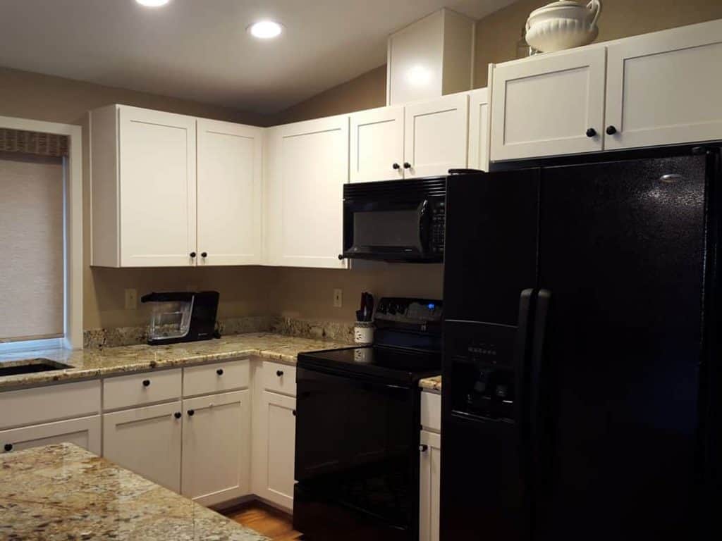 The homeowner wanted to keep the existing appliances but wanted to change all other elements. They especially wanted simple white cabinets and wood looking floors.