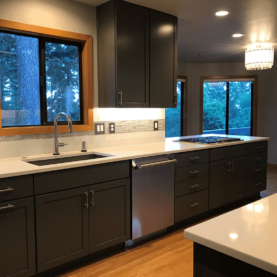 AFTER Kitchen complete with new painted cabinets, quartz countertops, glass subway tile with a mixed glass accent, and more!