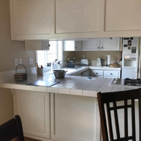 BEFORE The original white cabinets were still in good shape, but the white tile countertops did not provide the color contrast and visual interest that the homeowner wanted.