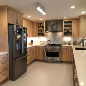 AFTER By eliminating the bulky soffits and installing taller upper cabinets, the ceilings look and feel higher. The natural maple cabinets with slab door style are exactly what the homeowner wanted!
