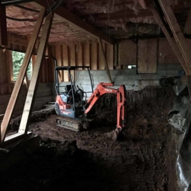 DURING In order to prepare the land for a 1300 square foot addition, we had to start with the proper dig out. We needed enough space under the existing home to create the desired 9 ft ceiling height.