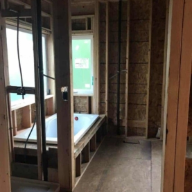 DURING The master bathroom soaking tub and shower pan are on site, and all the rough electrical and plumbing is complete.